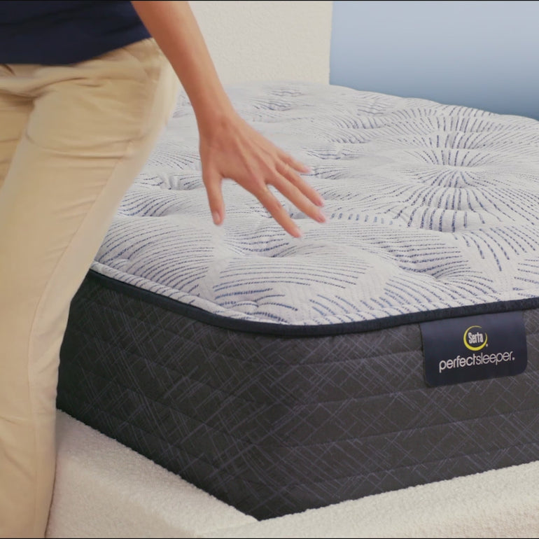 Person sitting on bed to show firmness level of Serta Perfect Sleeper medium mattress||feel: medium||level: enhanced