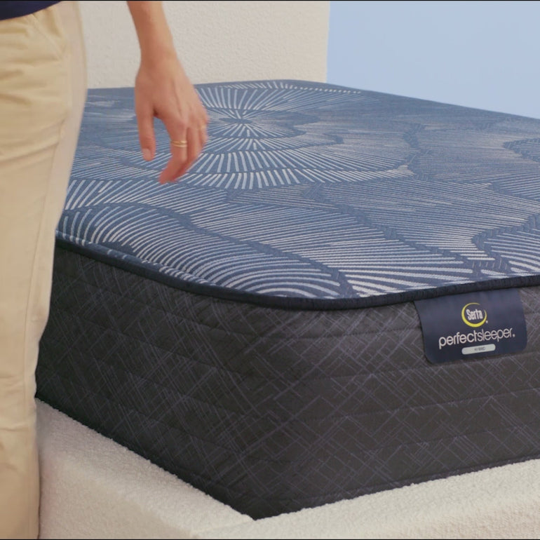 Person sitting on Serta Perfect Sleeper Hybrid medium mattress to show firmness||feel: medium||level: standard