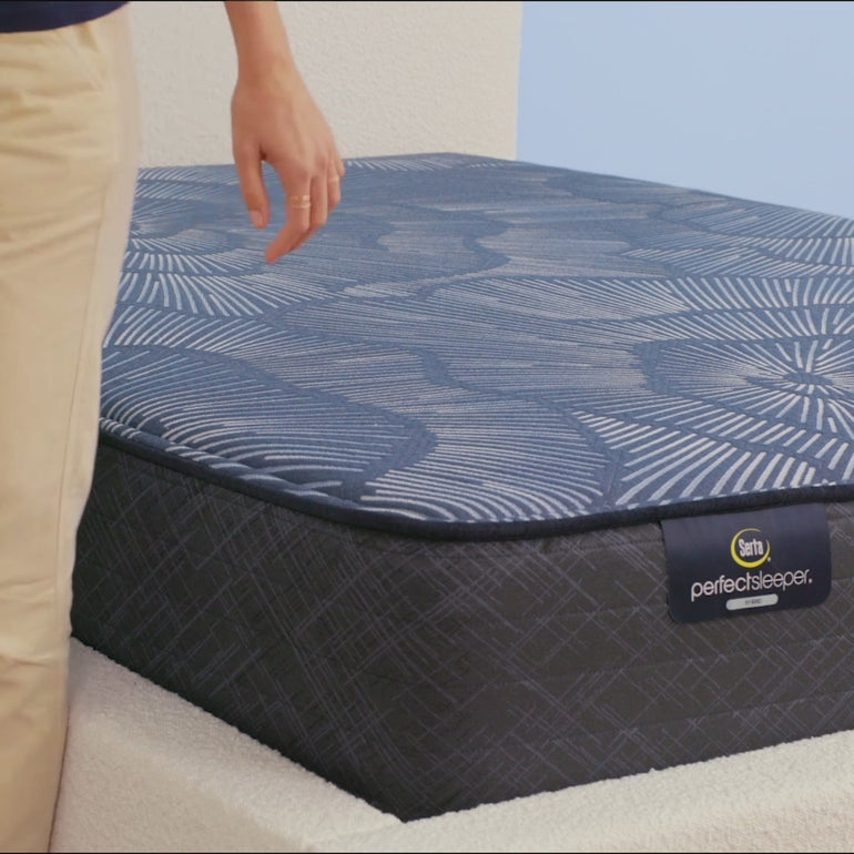 Person sitting on Serta Perfect Sleeper Hybrid firm mattress to show firmness||feel: firm||level: standard