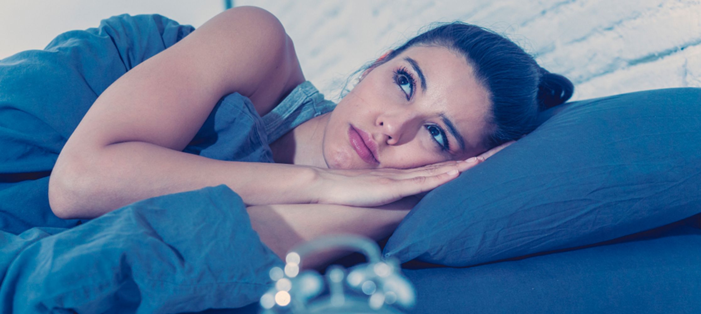 Woman sleeping in cozy blue bedding
