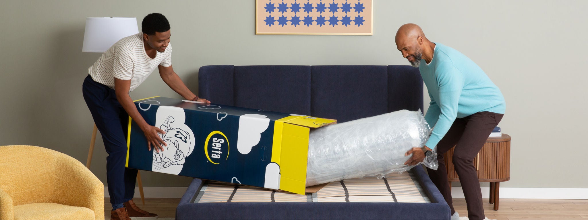 Two men unboxing a Serta mattress from the box.