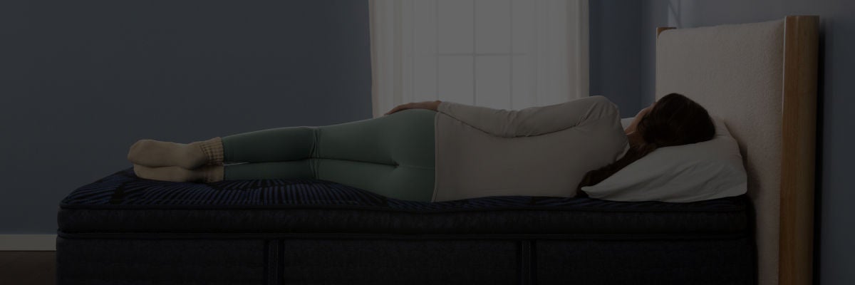 Woman laying on her right side on top of a Serta Mattress