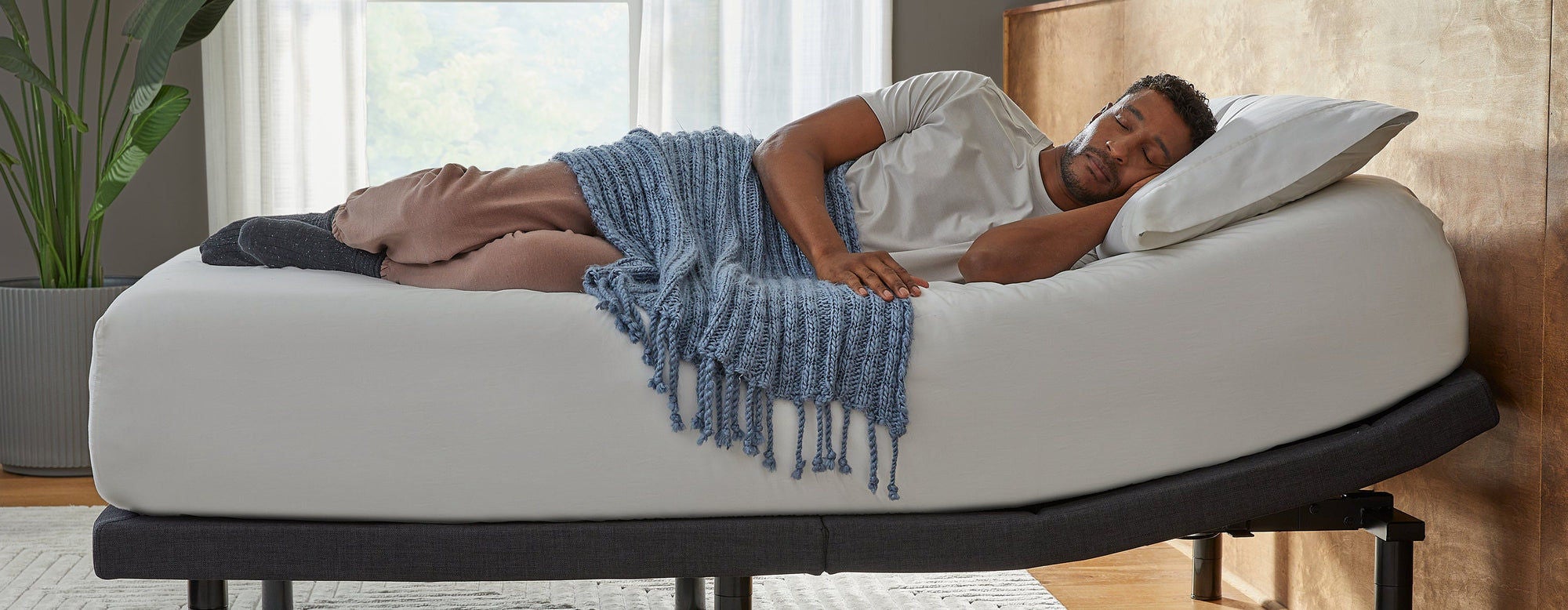 Man sleeping on adjustable bed with blanket