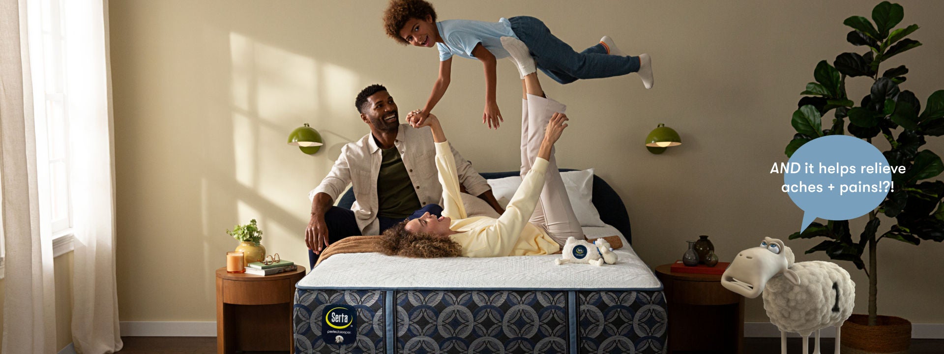 Family of 3 sitting, man sitting, woman lying on her back and balancing a boy on her legs, all on top of a Serta Perfect Sleeper mattress