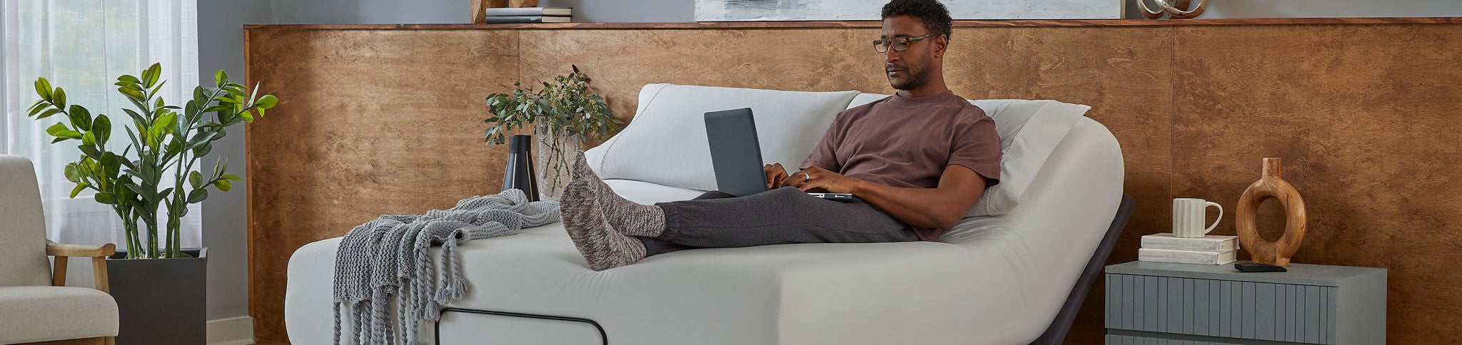 Man relaxing on adjustable bed with laptop