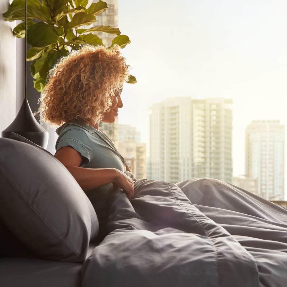Woman relaxing in modern bedroom setting