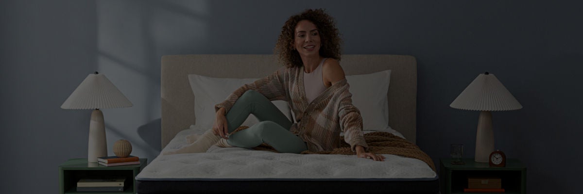 Woman smiling siting on top of a Serta mattress