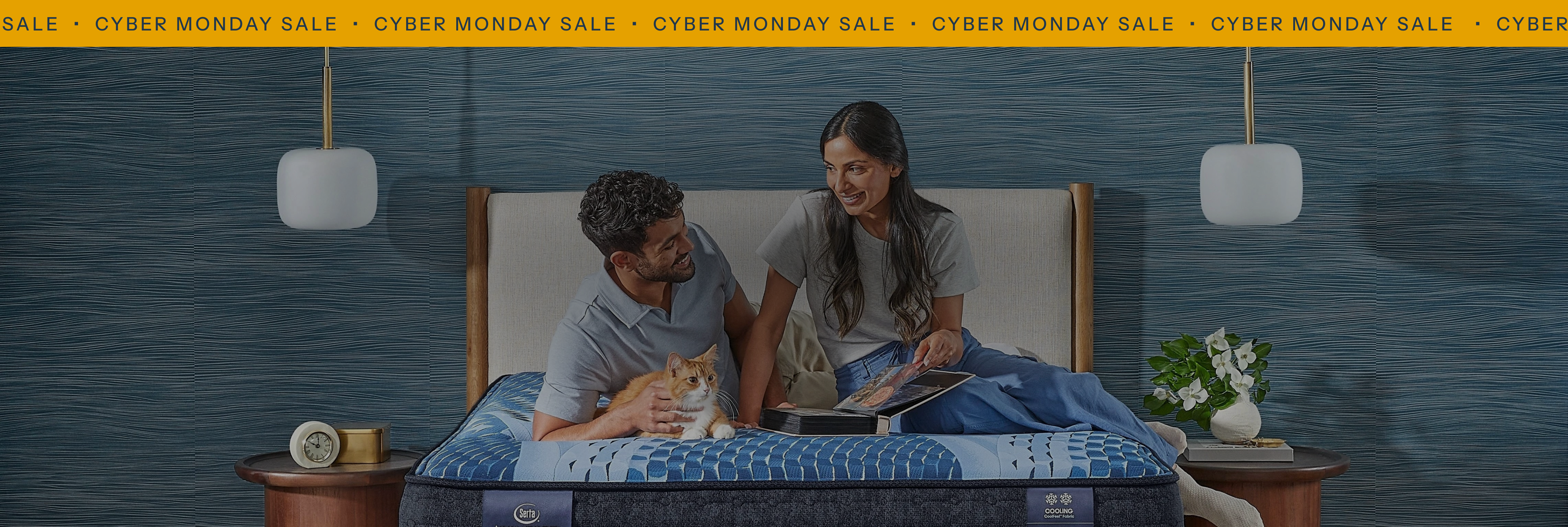 Couple relaxing on bed with Cyber Monday sale