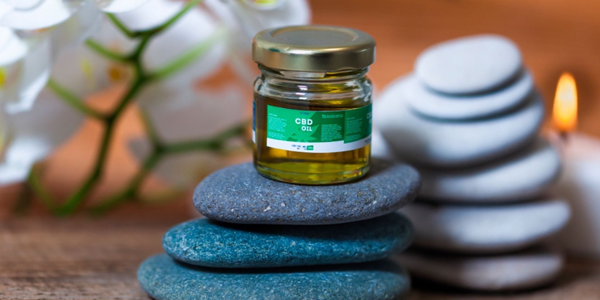 Small CBD oil jar on stacked stones