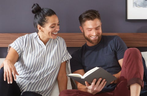 Couple reading together on a bed