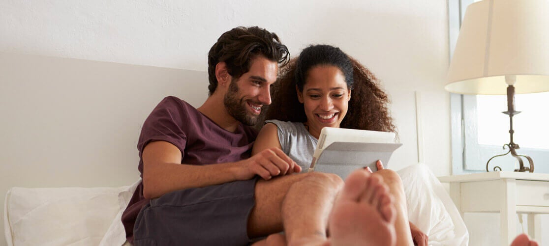 Couple reading together in cozy bedroom