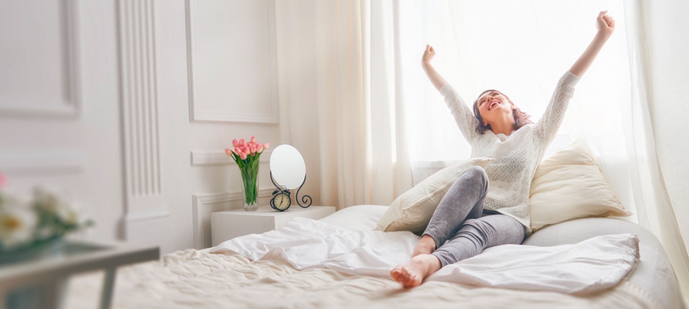 Woman stretching in cozy bedroom morning light