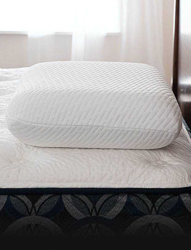 Serta Pillow on top of a Serta mattress in a brown bed frame