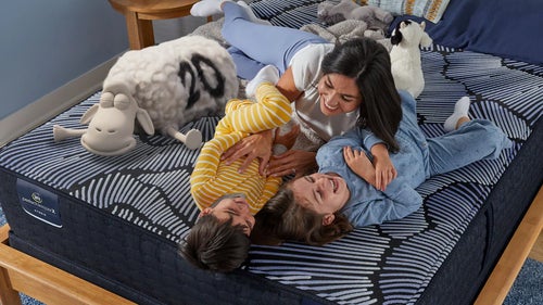 Family playing on patterned mattress