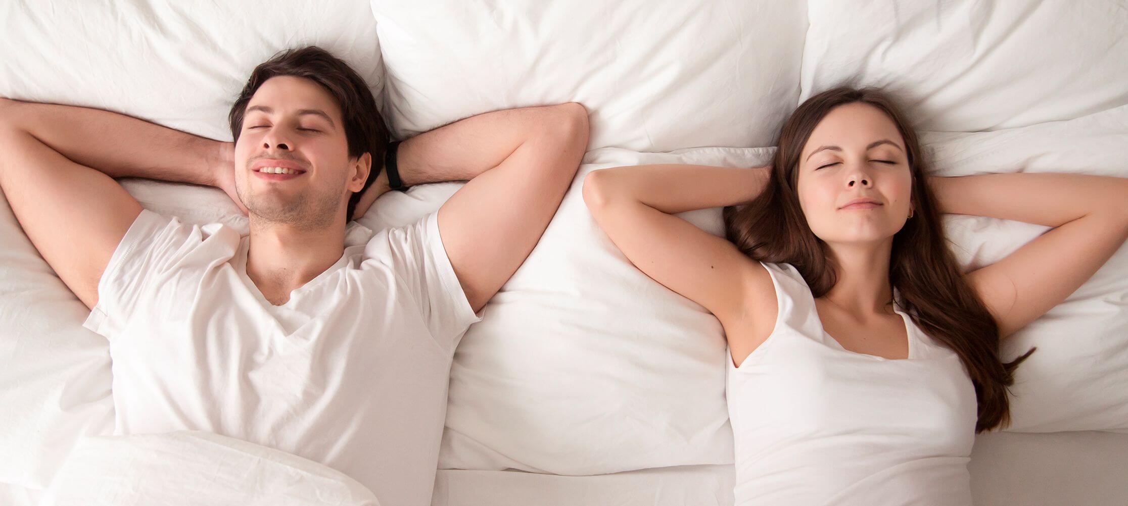 Couple relaxing on white bedding