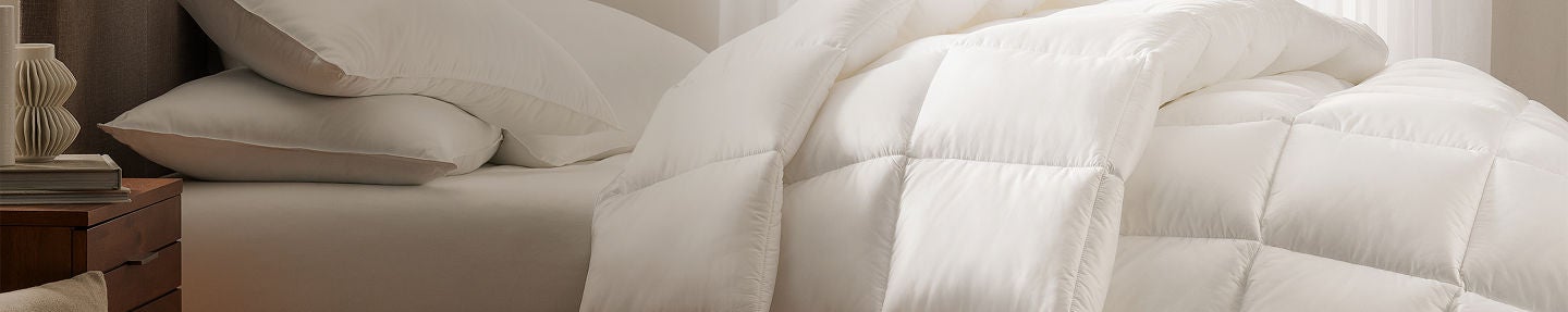 Serta comforter on top of a Serta mattress with 2 pillows on top of it.