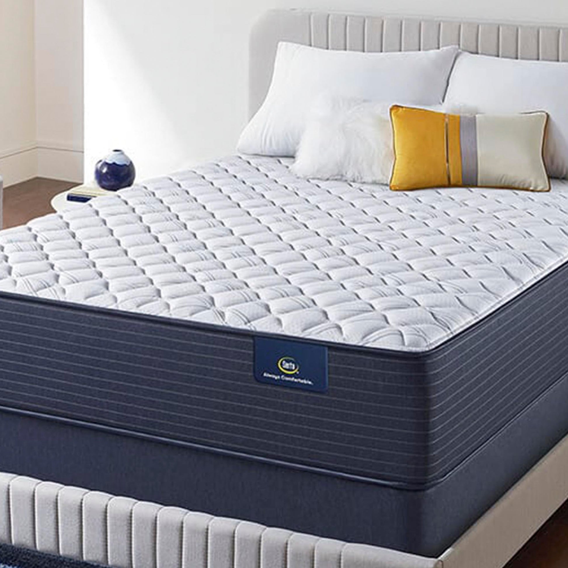 The The Serta Classic Elite Extra Firm 13" mattress  in a bedroom on a beige bed
