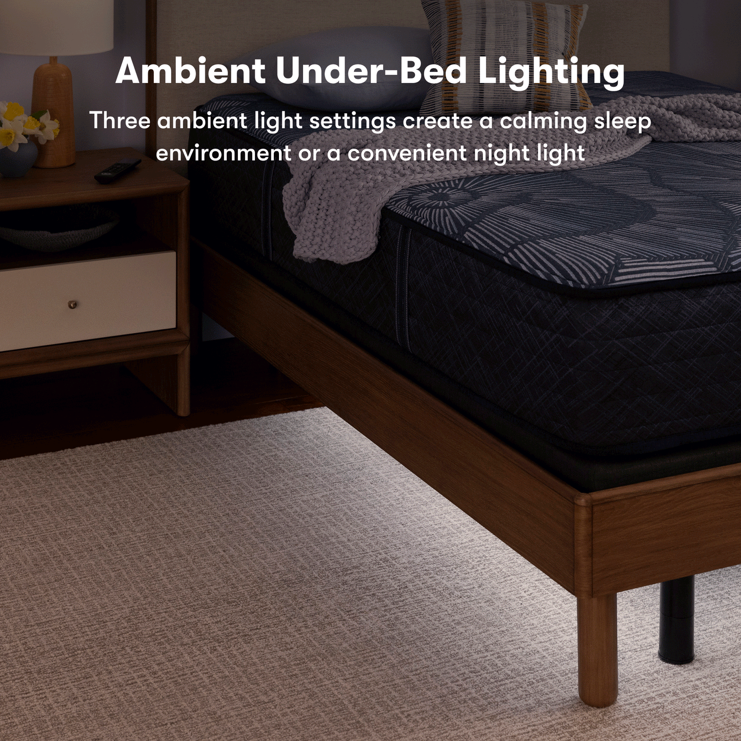 Perfect sleeper mattress, sitting on top of an adjustable base with both in a brown bed frame. 