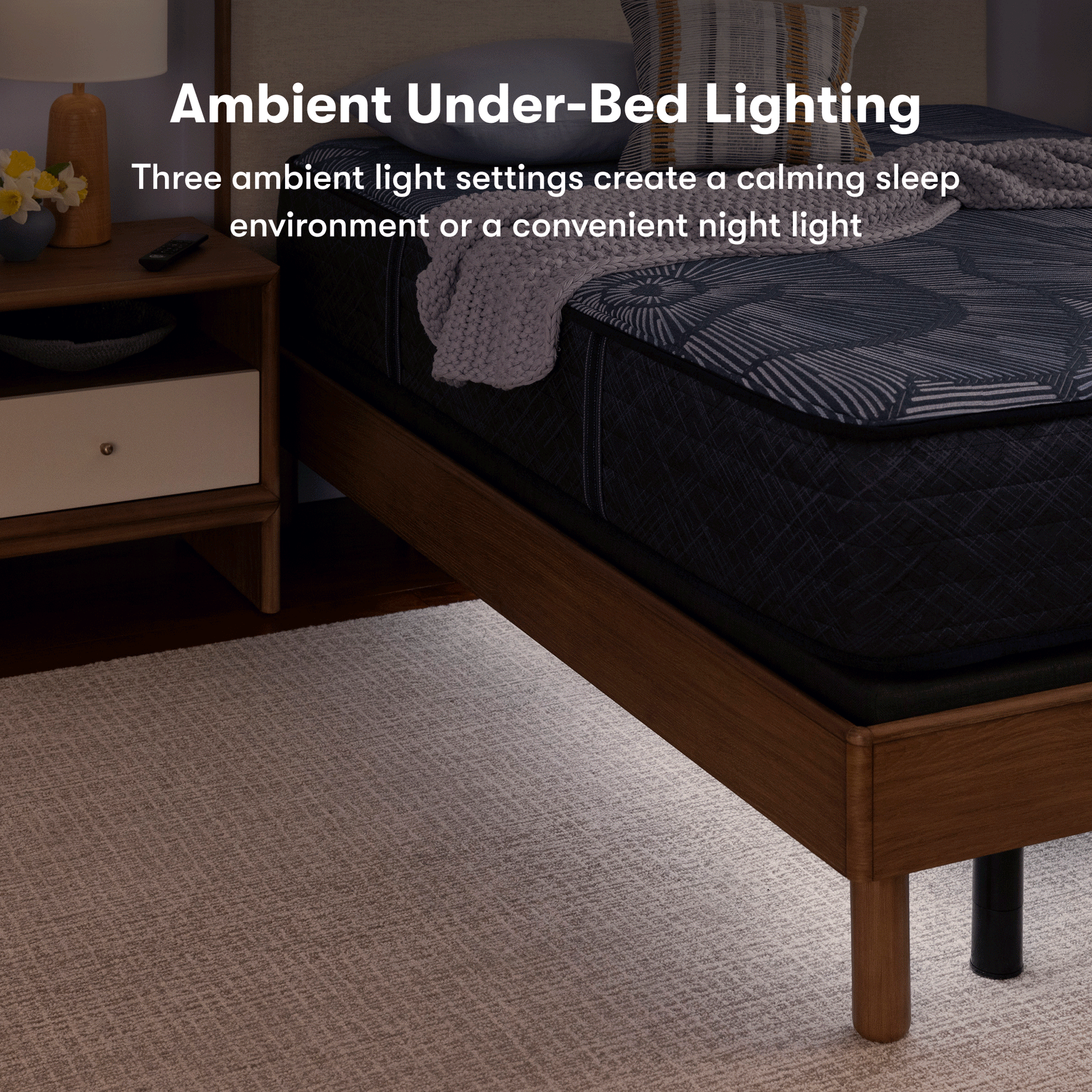 Perfect sleeper mattress, sitting on top of an adjustable base with both in a brown bed frame. 