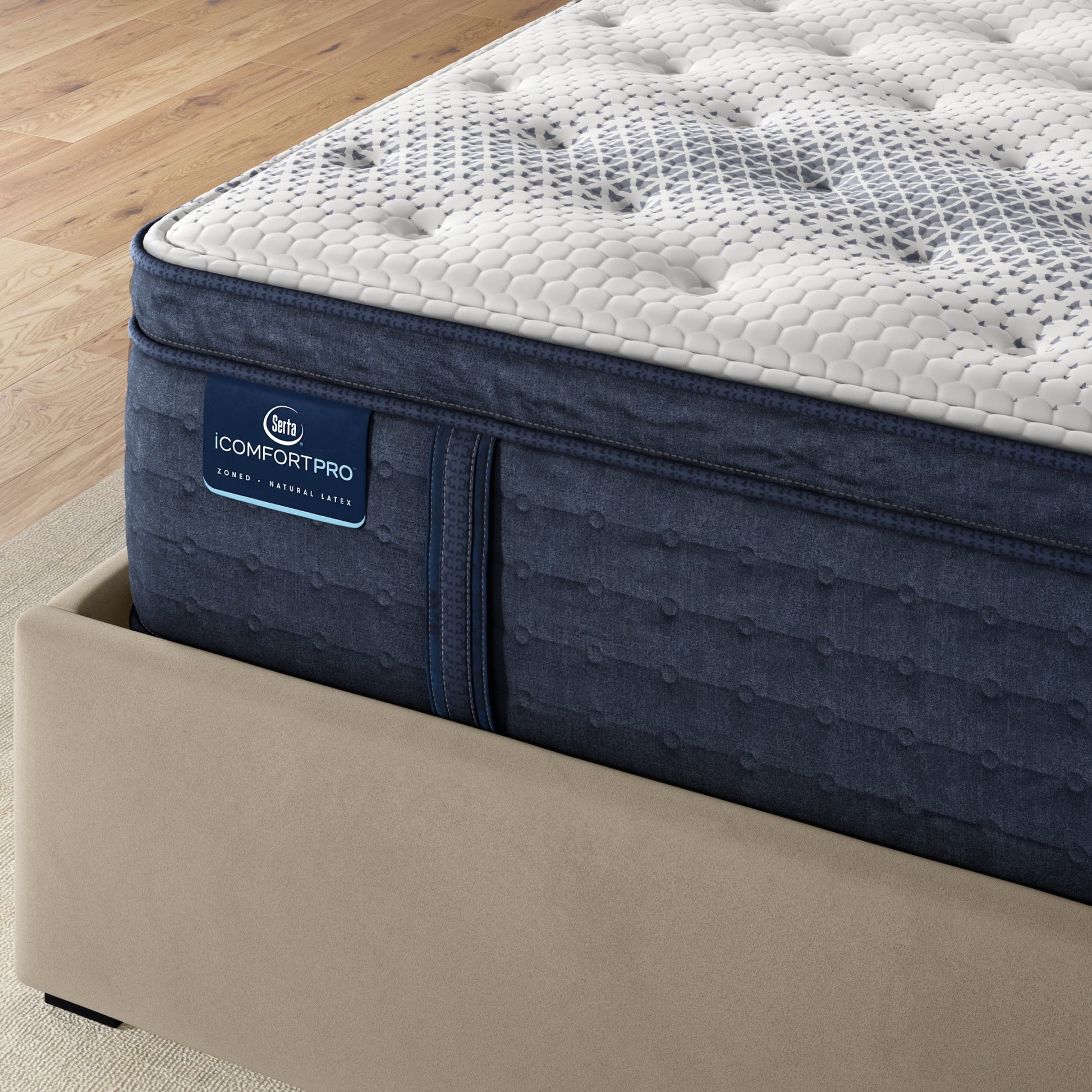 Corner of iComfortPro Buckingham Pillow Top Mattress sitting in a brown bedframe || feel: plush pillow top || level: Level 3