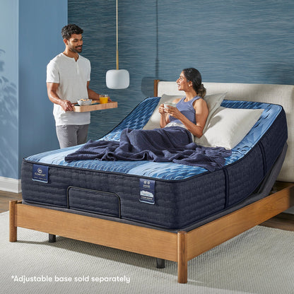 Woman siting in a slightly bent Serta iComfort mattress placed on an adjustable base looking at a man standing at the side serving breakfast in bed || feel: medium || level: Enhanced - 14"