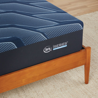 A corner of a wooden bed with a Serta iSeries plush blue mattress||feel: plush||level: Ultimate