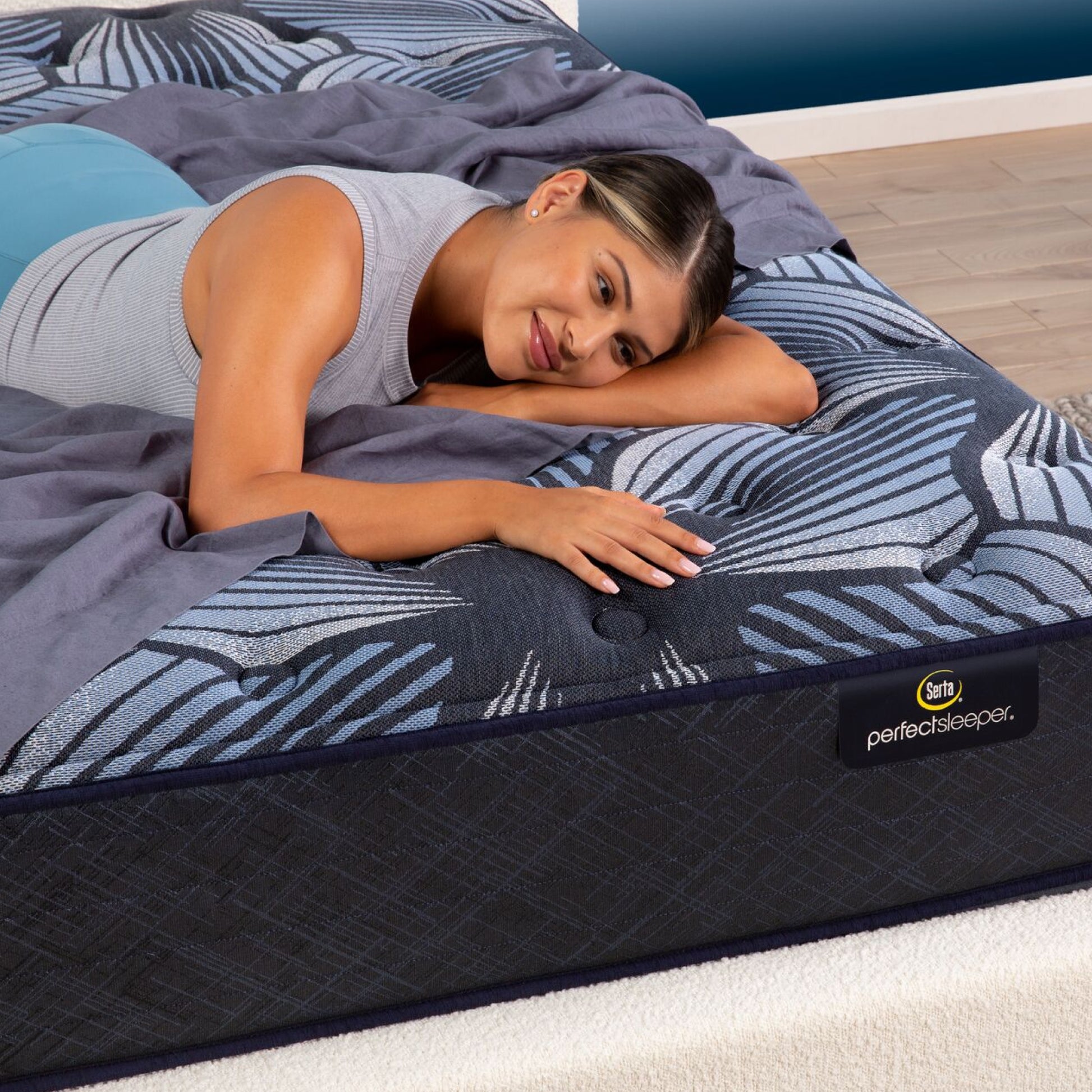 A woman laying in a bedroom on the Serta Perfect Sleeper Sleep Excellence mattress | feel: medium pillow top