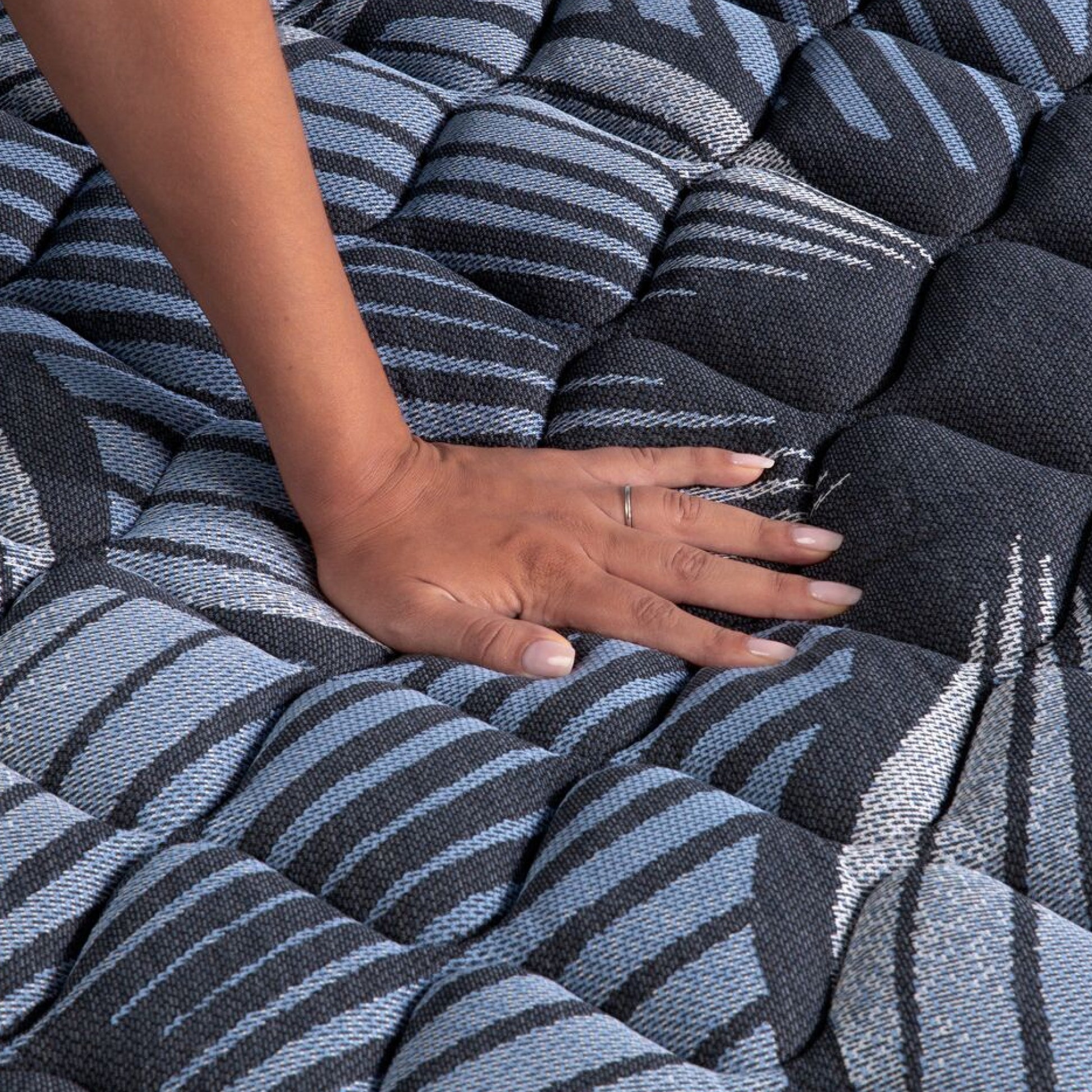 A hand pressing on the Serta Perfect Sleeper Sleep Excellence mattress showing it's firmness  | feel: Firm