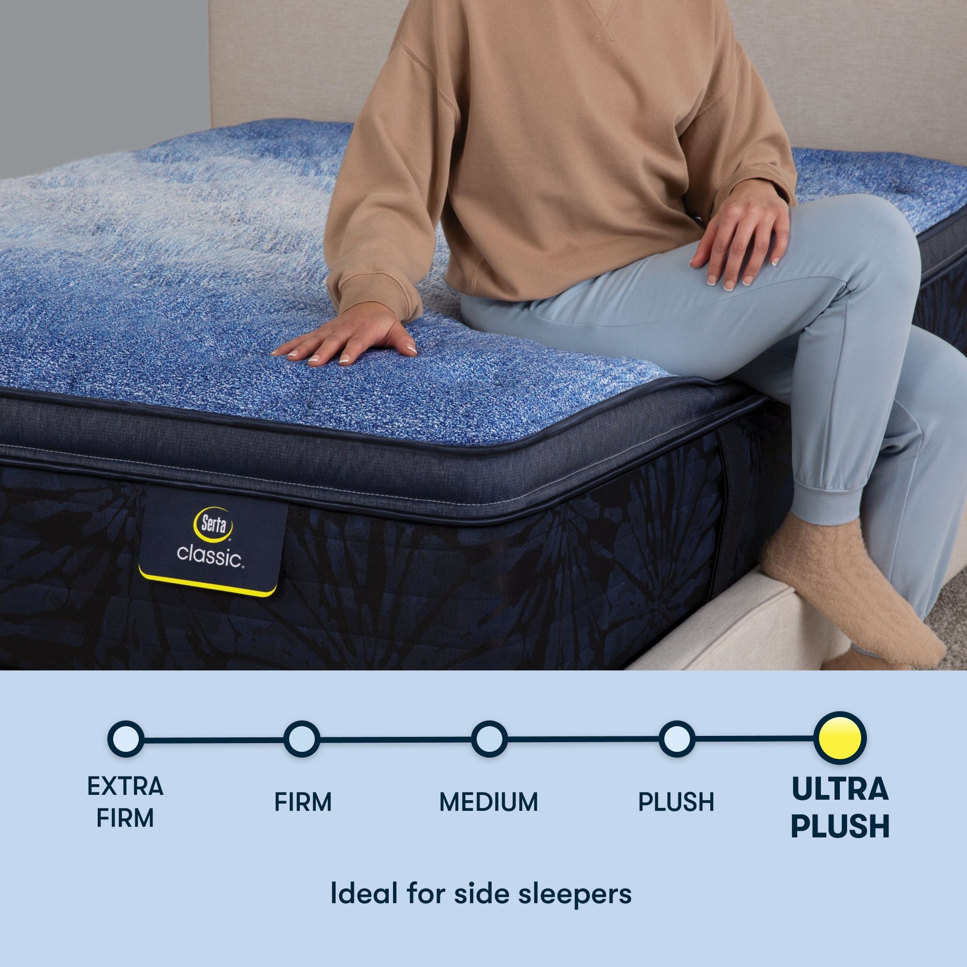 Woman sitting on a Serta classic plush pillow  top mattress with her right hand placed on the mattress ||feel: plush pillow top ||level: enhanced