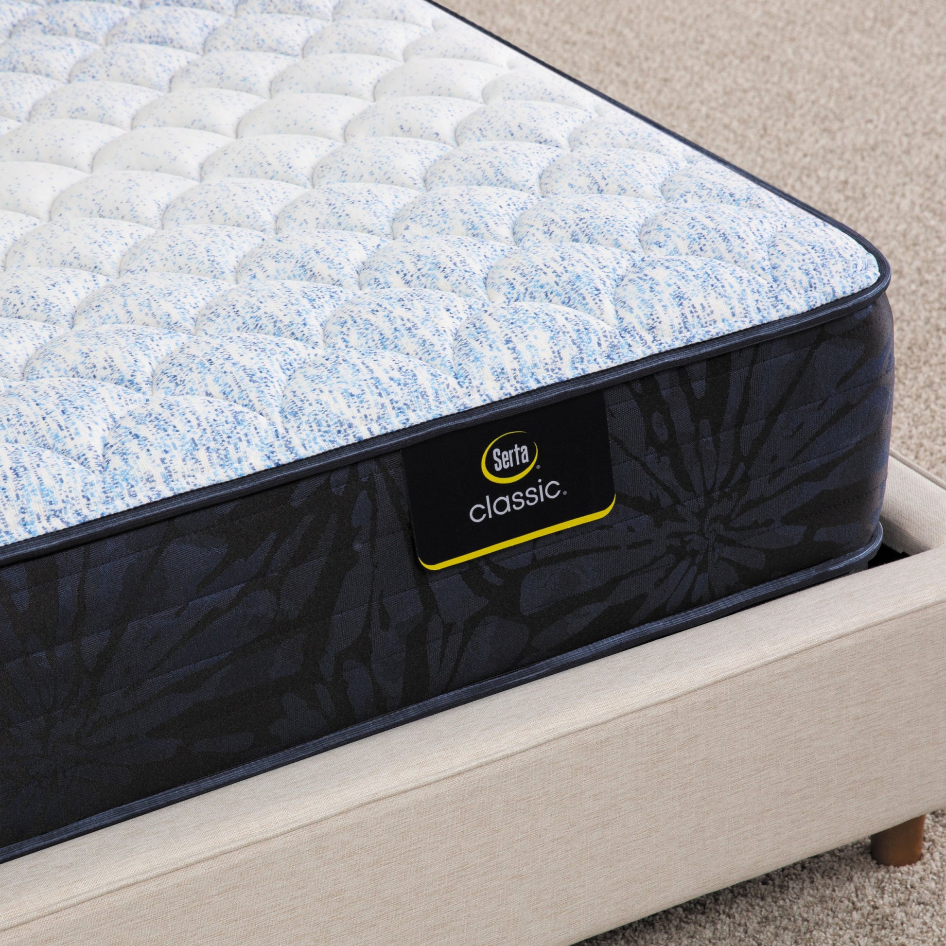 Corner of Serta classic alden medium mattress sitting in a beige bed frame ||feel: medium ||level: standard