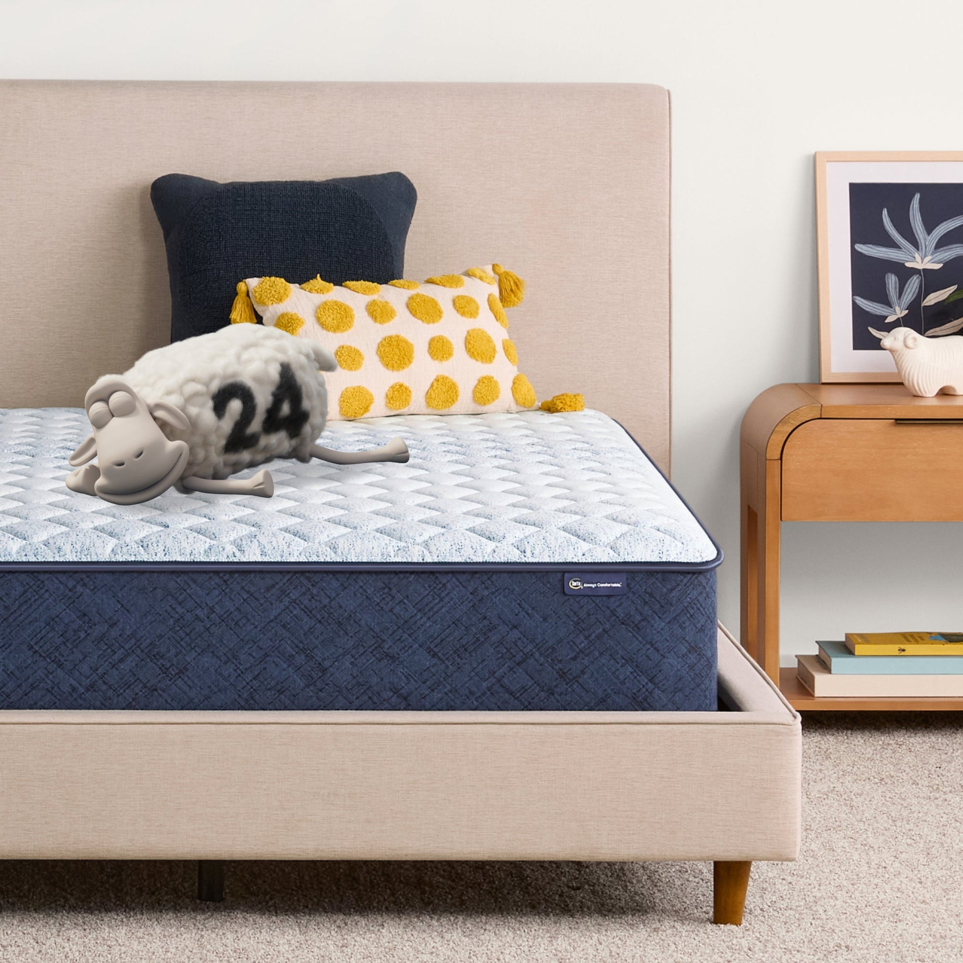 Sheep laying down with its eyes closed on an 12 inch hybrid mattress sitting in a beige bedframe || feel: Medium