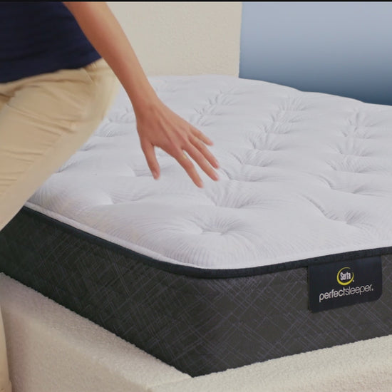 Person sitting on bed to show firmness level of Serta Perfect Sleeper plush mattress||feel: plush||level: standard