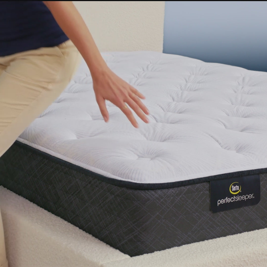 Person sitting on bed to show firmness level of Serta Perfect Sleeper plush mattress||feel: plush||level: standard
