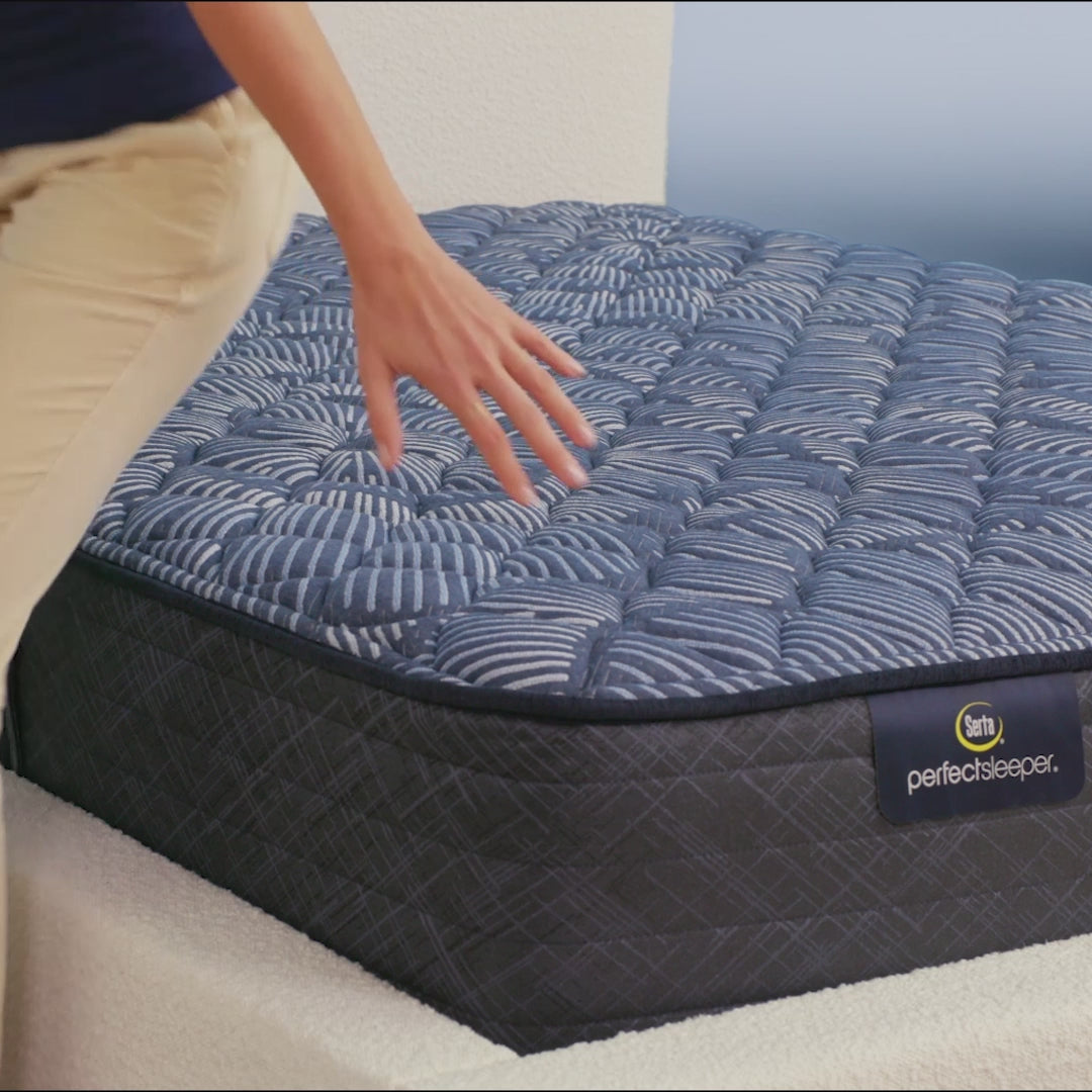 Person sitting on bed to show firmness level of Serta Perfect Sleeper extra firm mattress||feel: extra firm||level: ultimate