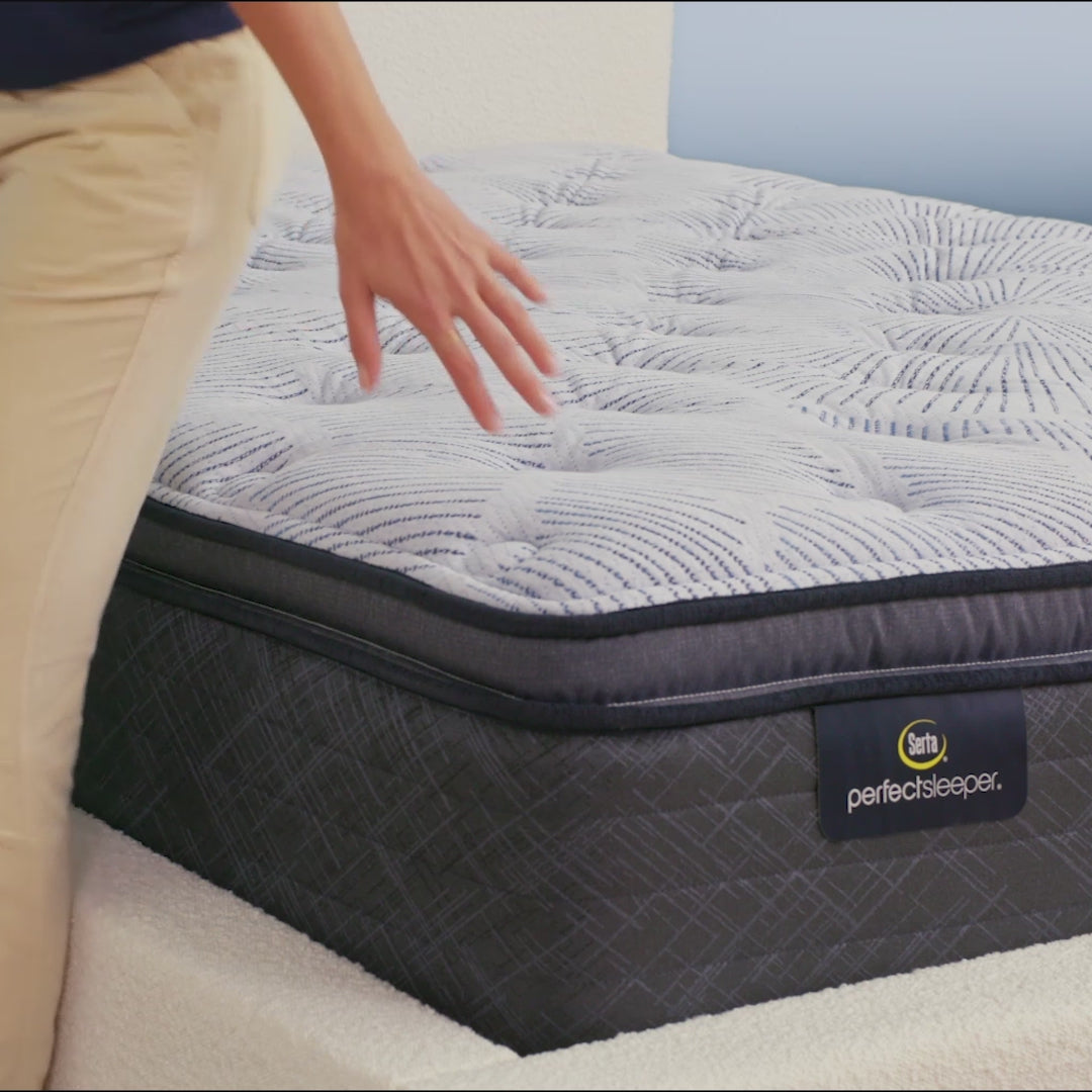 Person sitting on bed to show firmness level of Serta Perfect Sleeper plush pillow top mattress||feel: plush pillow top||level: enhanced