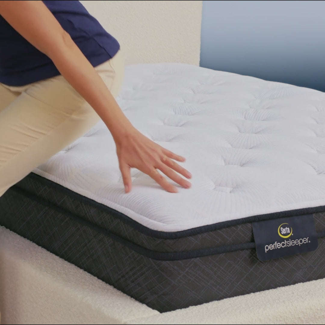 Person sitting on bed to show firmness level of Serta Perfect Sleeper plush euro top mattress||feel: plush euro top||level: standard