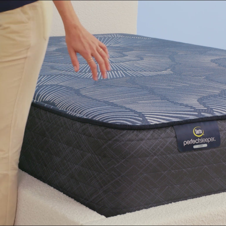 Person sitting on Serta Perfect Sleeper Hybrid mattress to show firmness||feel: firm||level: enhanced
