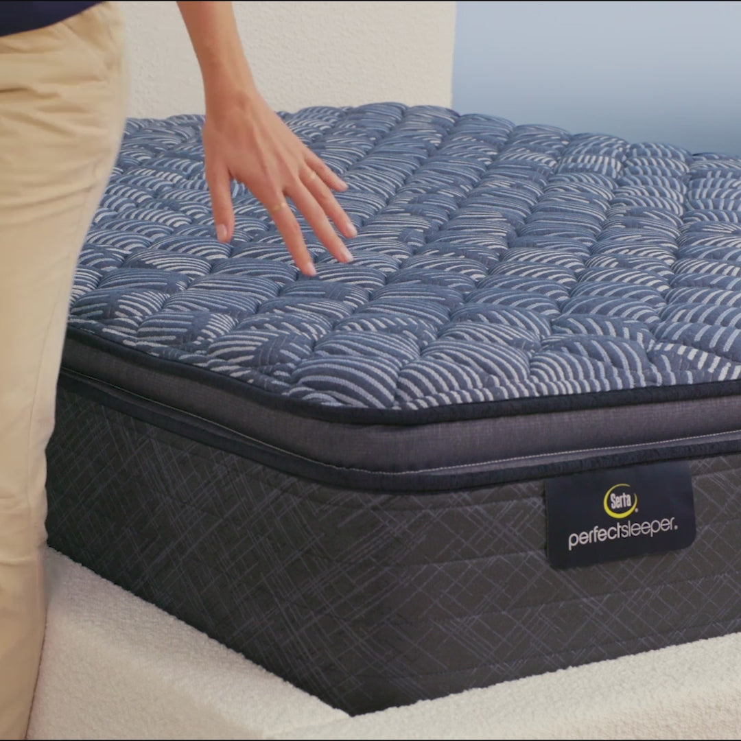 Person sitting on bed to show firmness level of Serta Perfect Sleeper firm pillow top mattress||feel: firm pillow top||level: ultimate