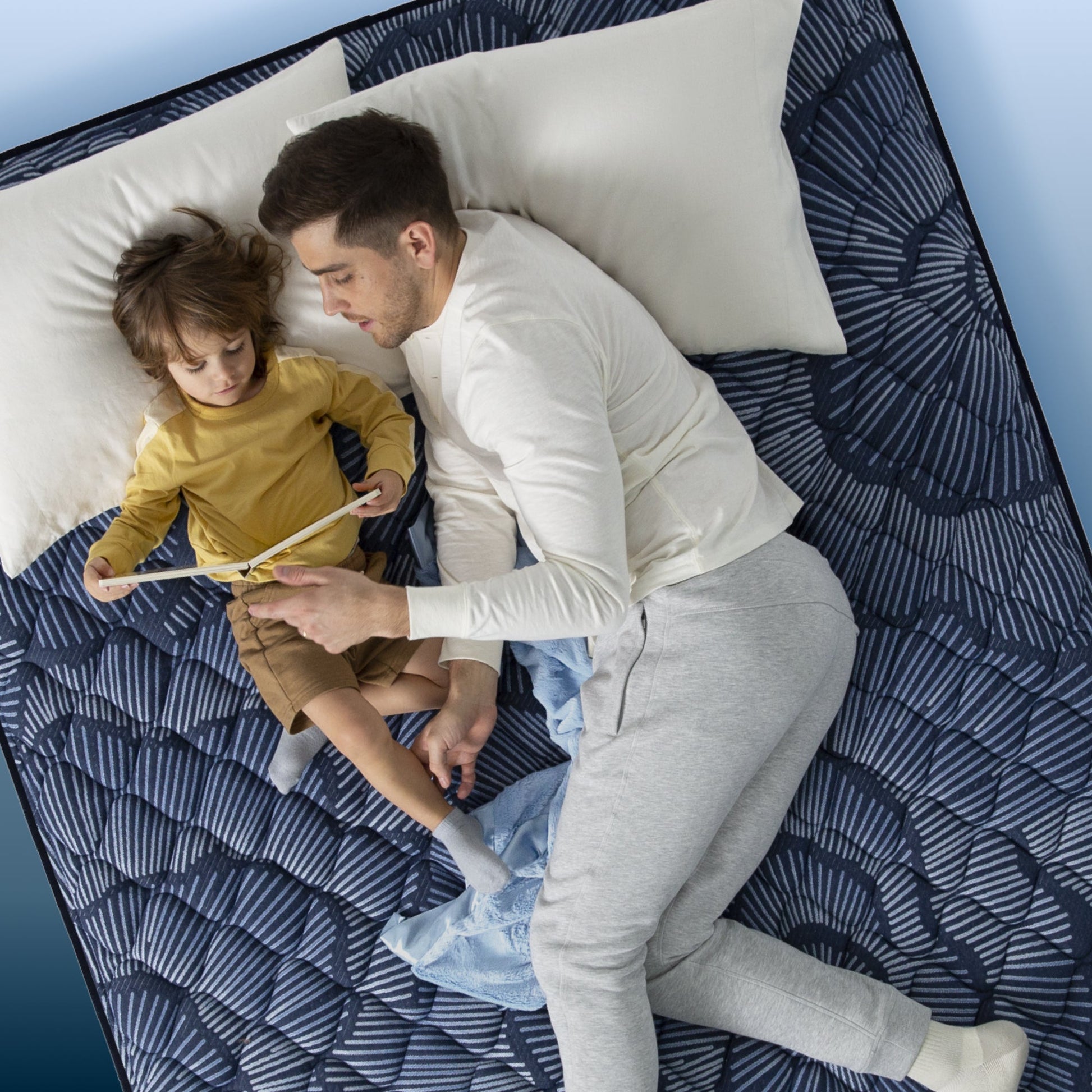 Little boy and father reading in bed on a Serta Perfect Sleeper mattress||feel: plush||level: ultimate