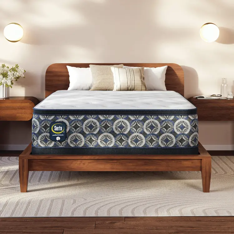 Serta perfect sleeper plush mattress on a wooden bed frame in a bedroom setting