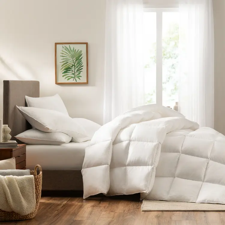 Serta Down Illusion Down Alternative Comforter - Extra Warmth draped on top of a mattress with 4 pillows on top of it in a bedroom setting.