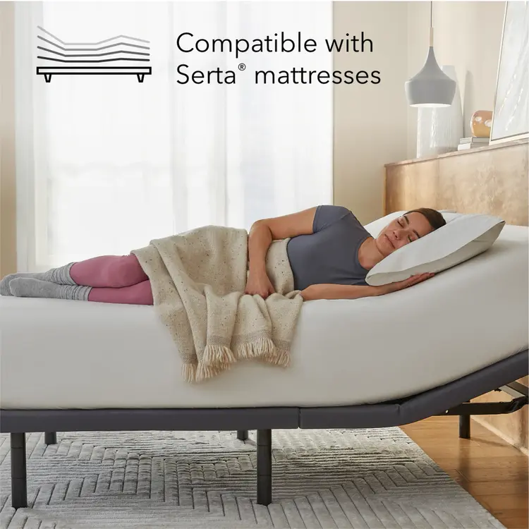 Woman lying on a Beautyrest mattress on top of a Pearl adjustable base with a pillow, surrounded by a blanket, in a bedroom setting.