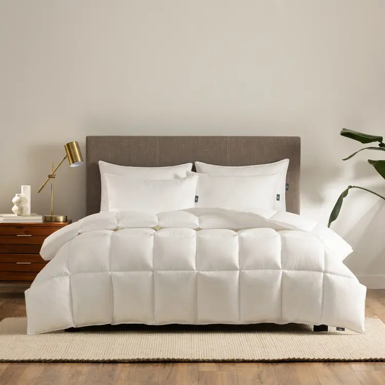 The Serta Down Illusion Down Alternative Comforter on a mattress