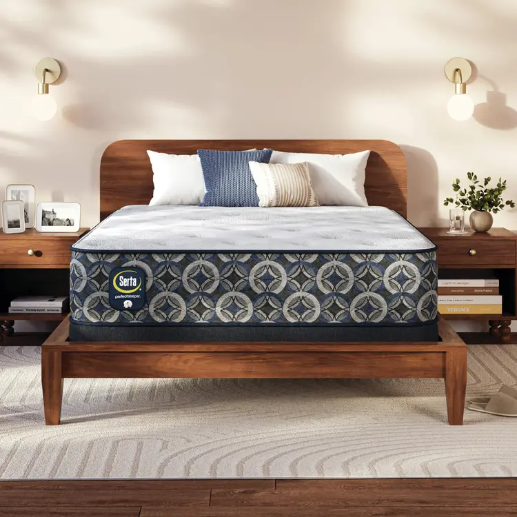 Serta Perfect Sleeper medium mattress on a wooden bed frame with pillows in a bedroom setting