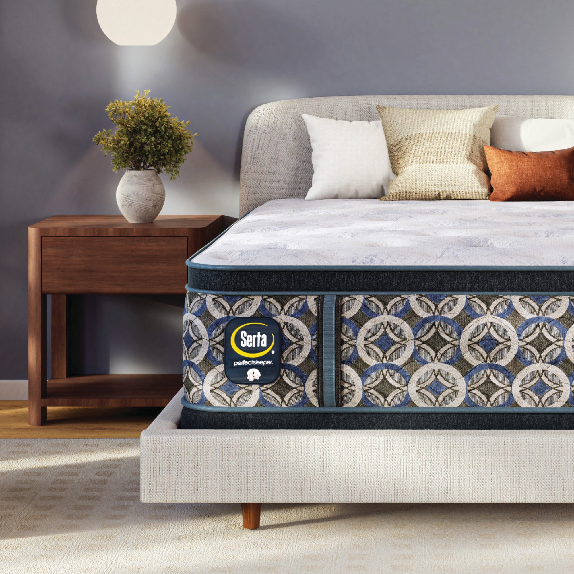 Serta perfect sleeper plush mattress in a bedroom setting with a nightstand and decorative pillows.