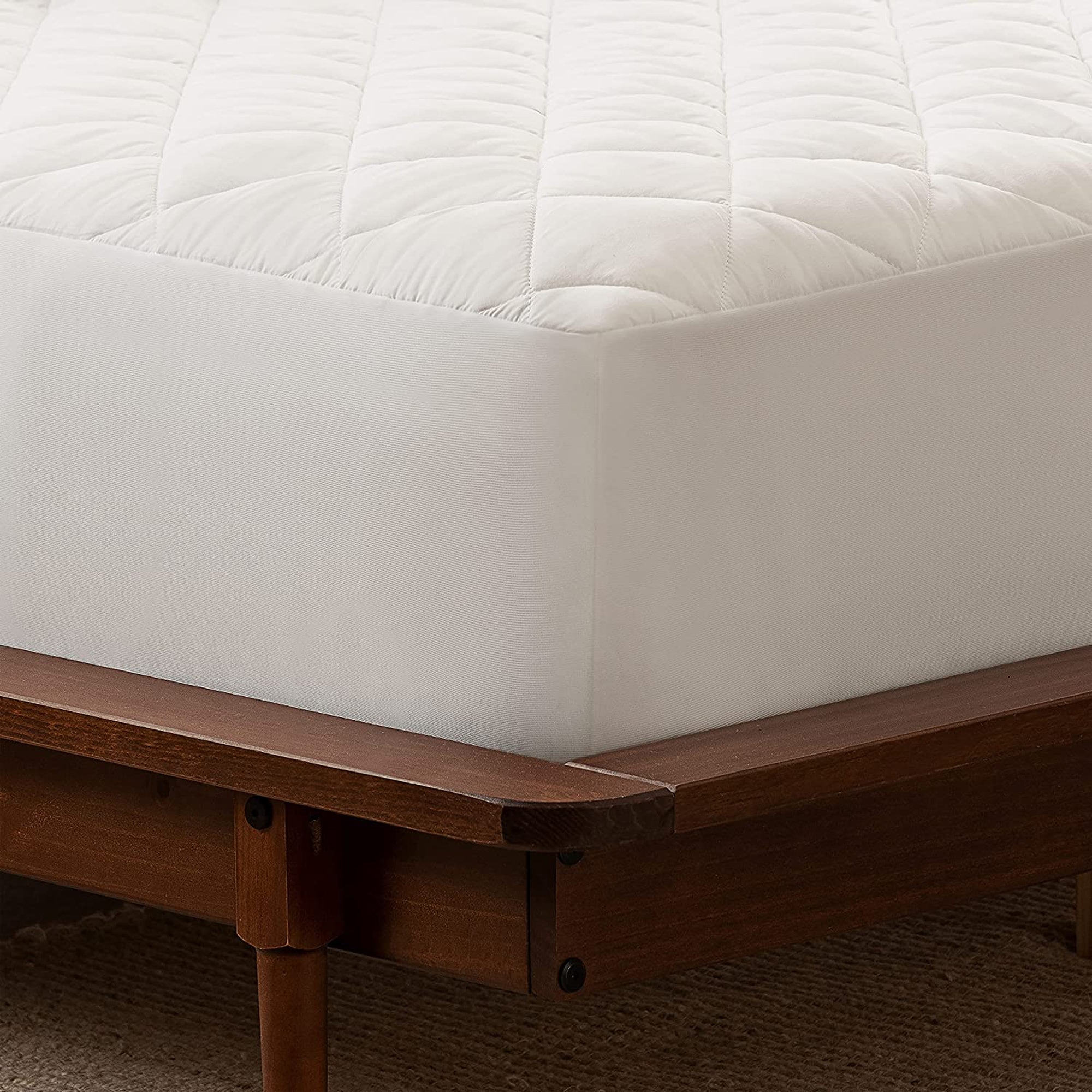 A closeup of the corner of Serta Power Clean Waterproof Mattress Pad on a bed