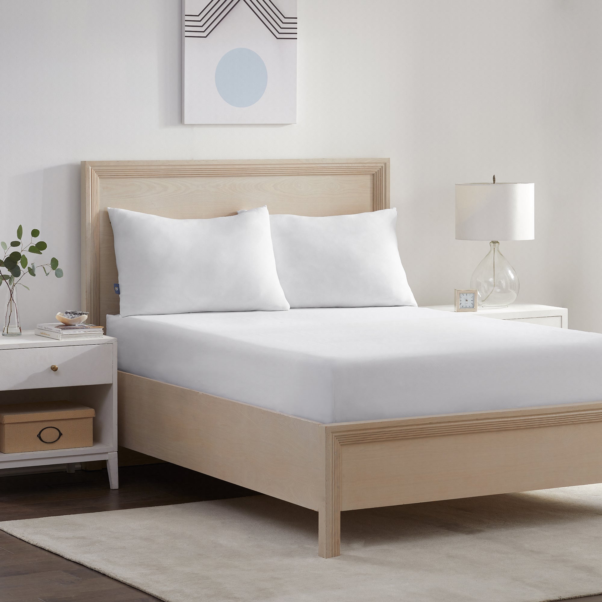 Serta Power Chill Pillow Protector wrapped around a mattress in a brown bed frame with 2 pillows on top of it.
